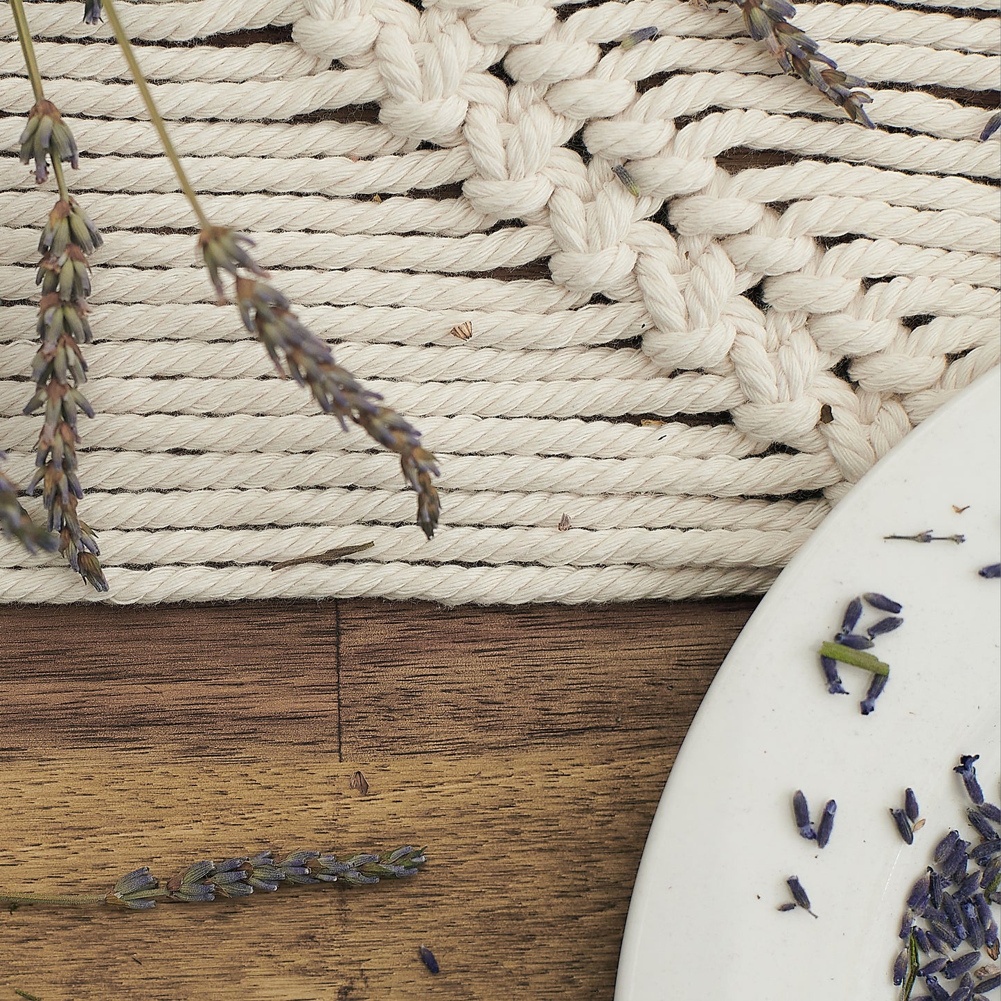 Close up view of the details of natural white macrame table runner decorated with dried lavender. 