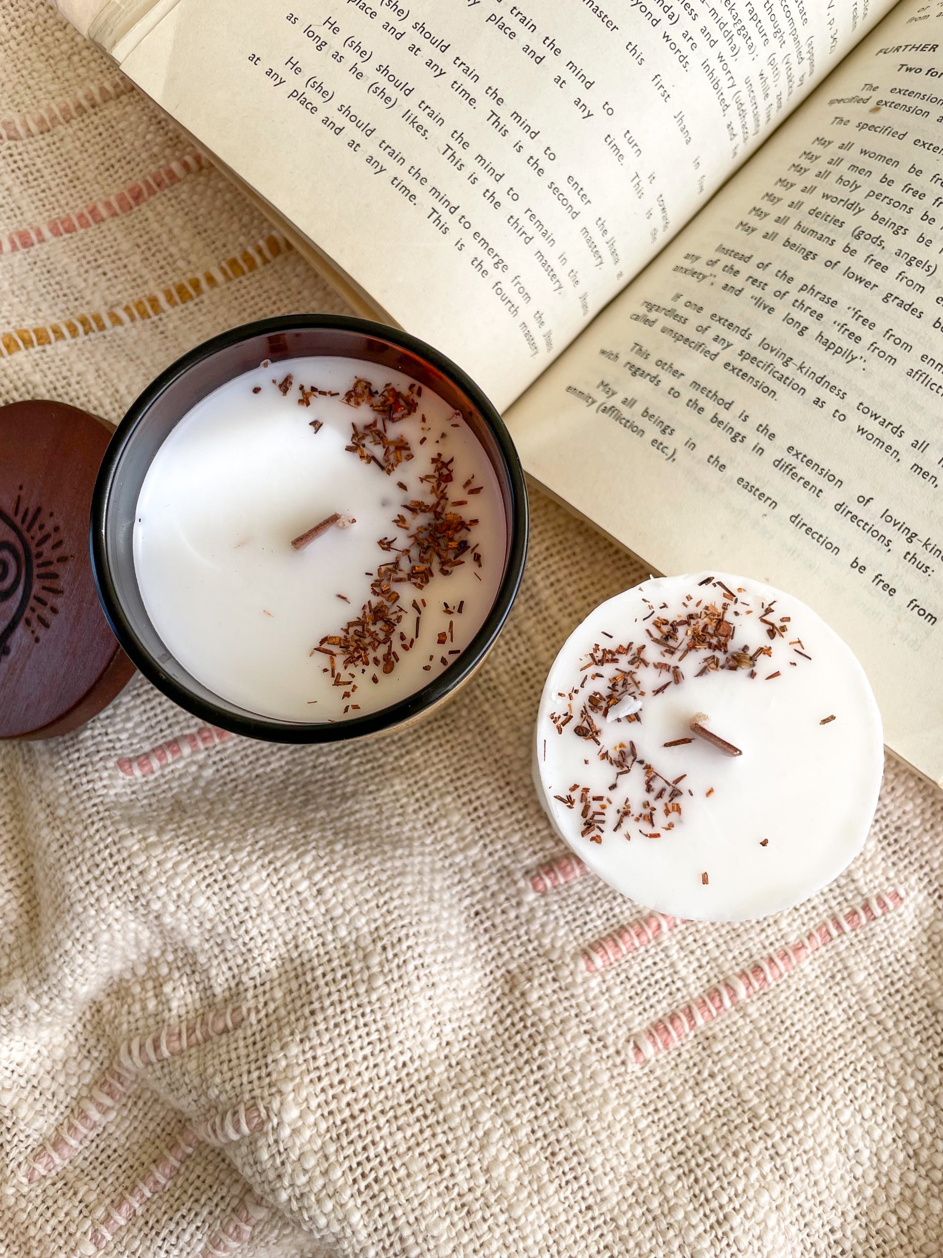 Our Leura candle gift set which includes a Leura soywax candle in a jar and a candle refill displayed next to a vintage style opened book