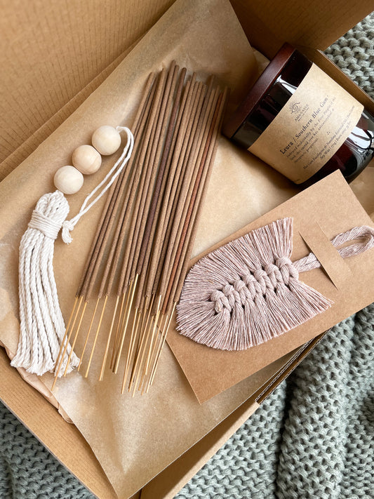 Close up photo of Calm vegan friendly handmade gift box for women. Contains 20 hand rolled natural incense sticks, 1 natural soywax candle in a jar, macrame beaded tassel, macrame feather bookmark. 