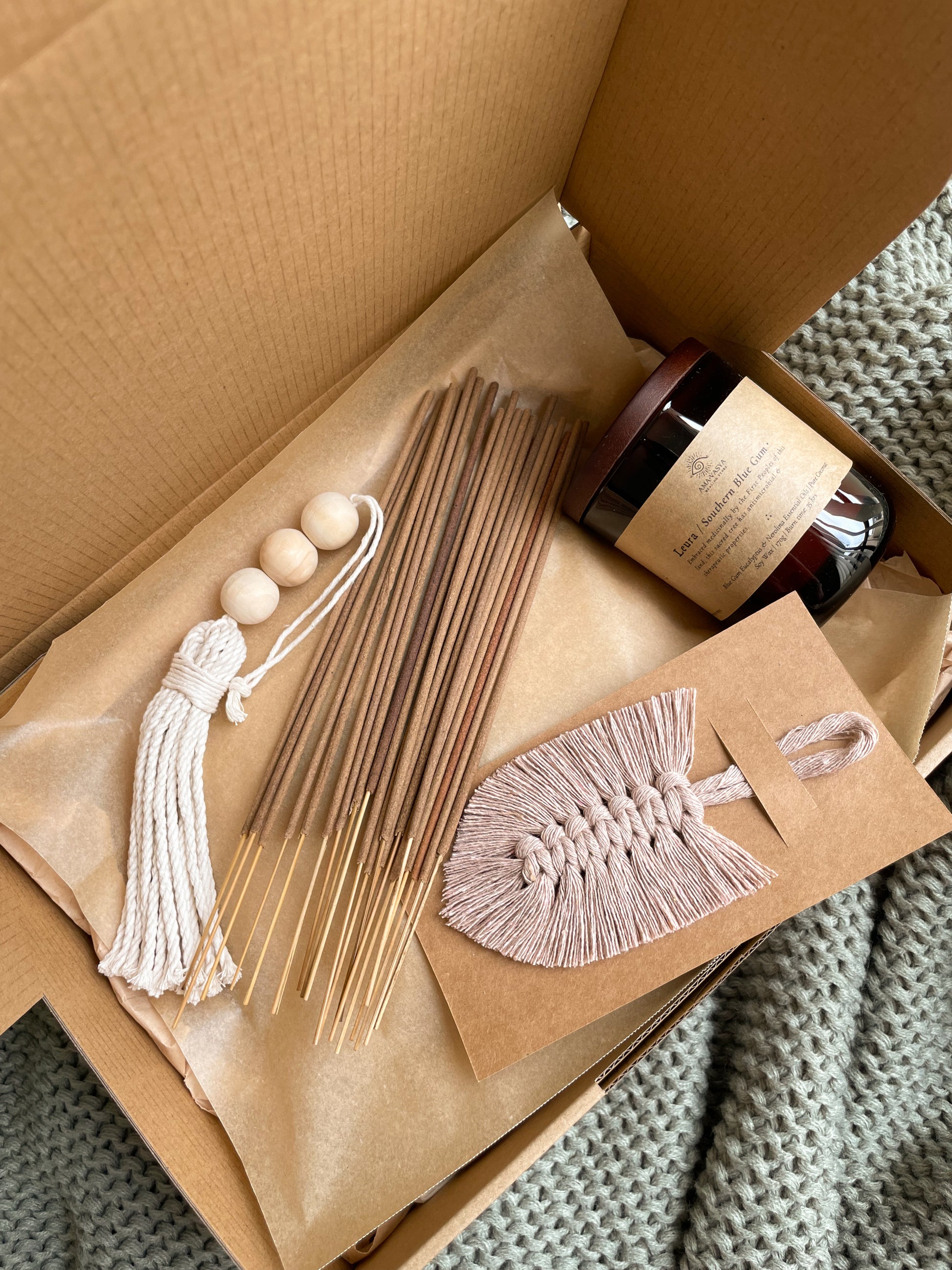Close up photo of Calm vegan friendly handmade gift box for women. Contains 20 hand rolled natural incense sticks, 1 natural soywax candle in a jar, macrame beaded tassel, macrame feather bookmark. 