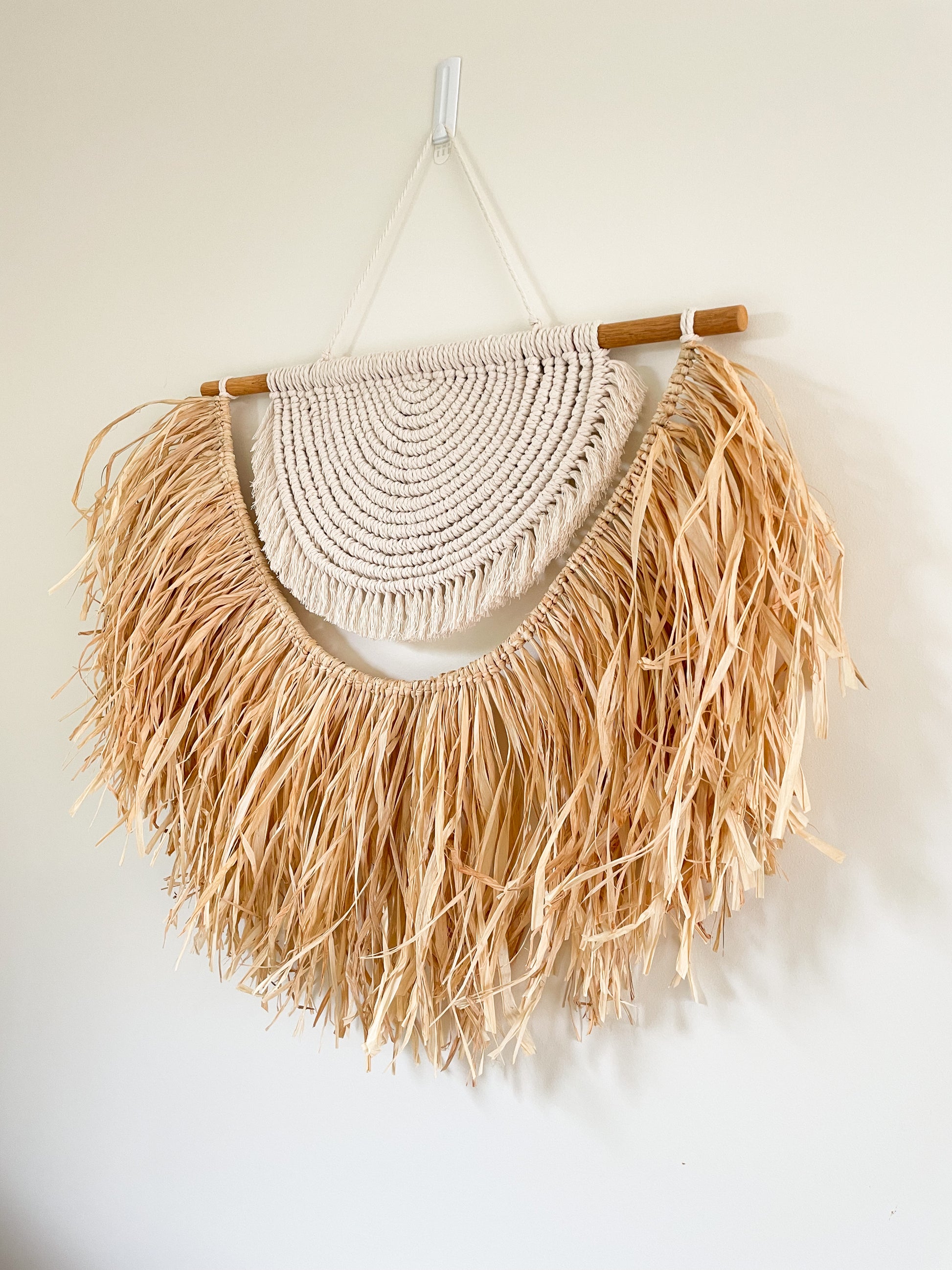 Large macrame and raffia wall hanging hanged on a wall 