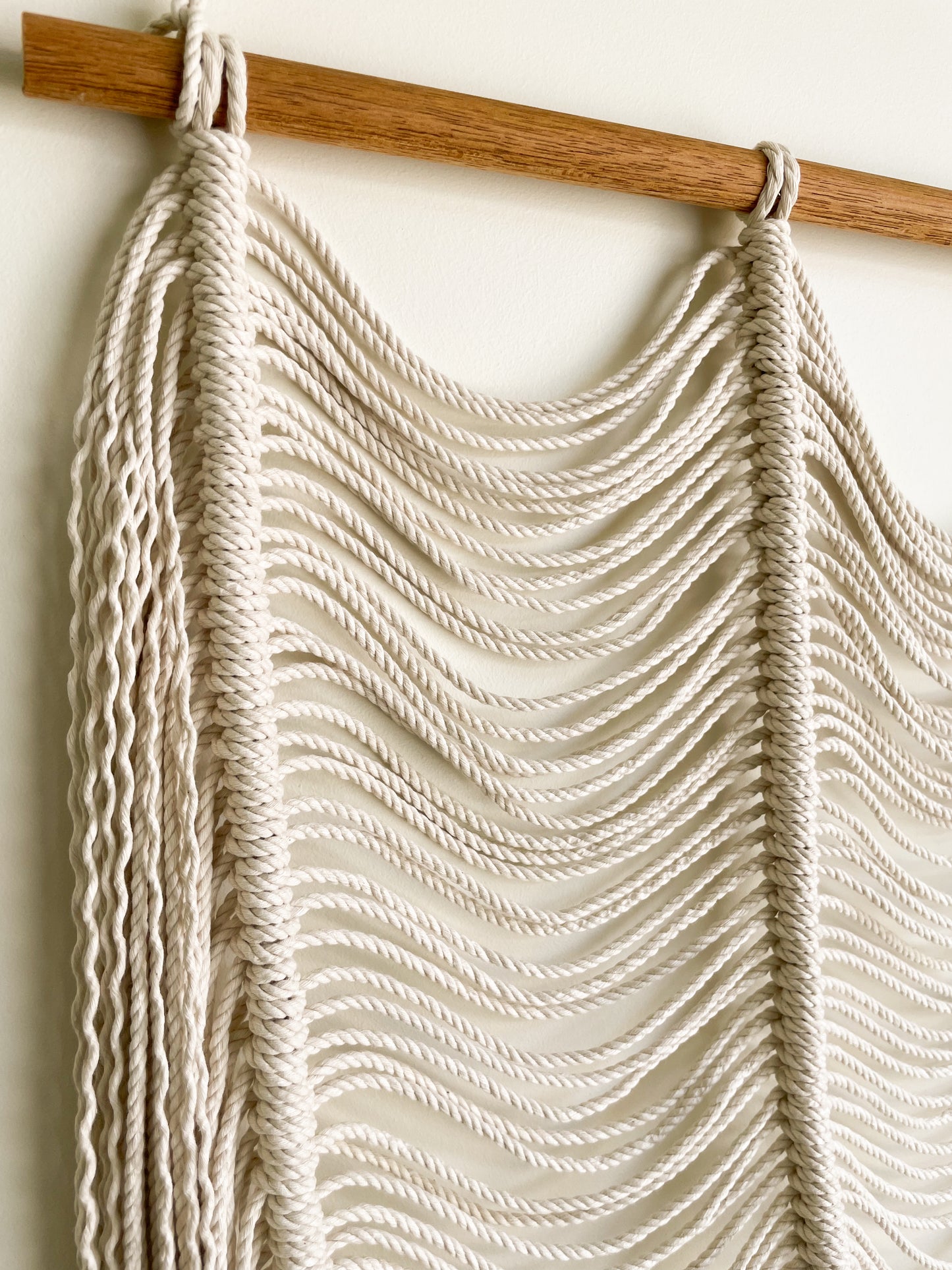 Closeup view of a modern macrame wall hanging hanged on a wall