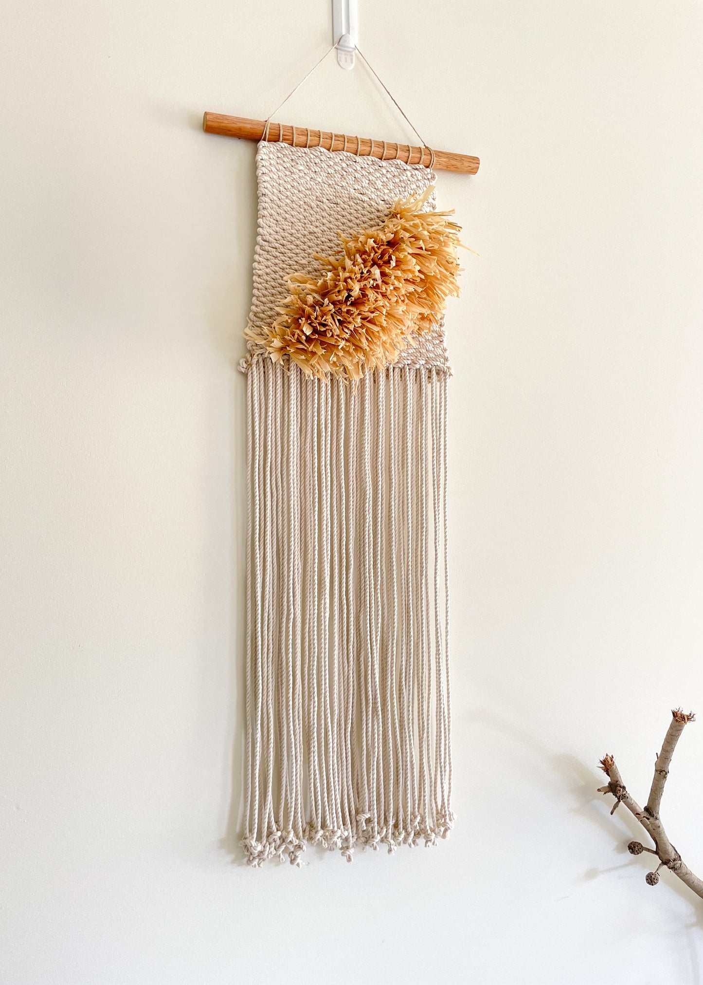 Closeup view of a raffia and cotton wall hanging hanged on a wall 