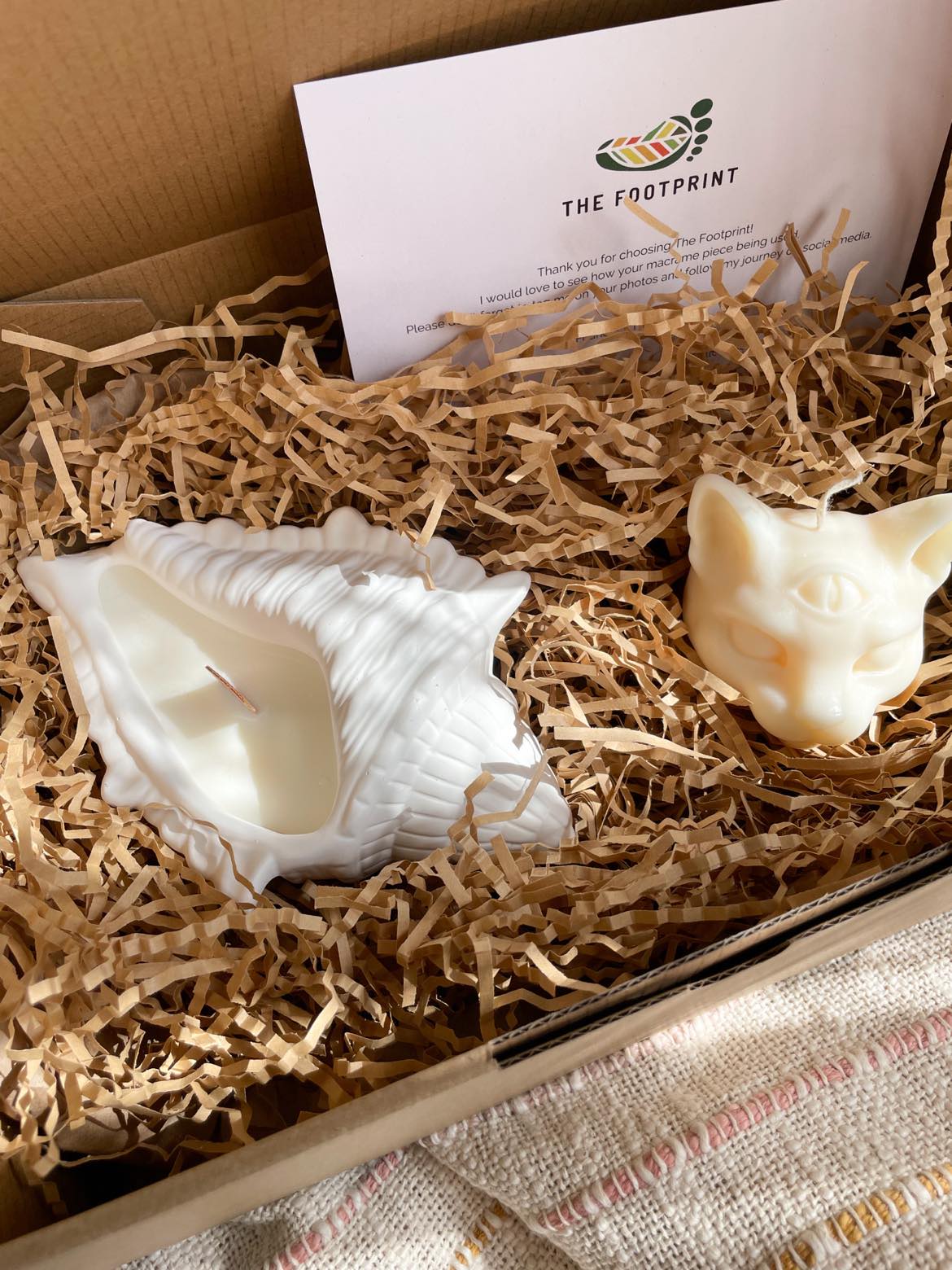 Seashell candle and cat candle in the standard packaging box - a kraft paper box. 