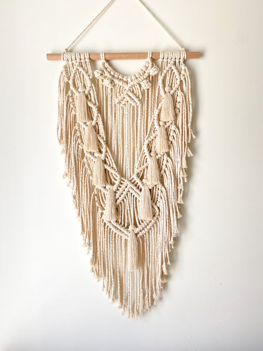 Natural white macrame wall hanging hanged on a white wall