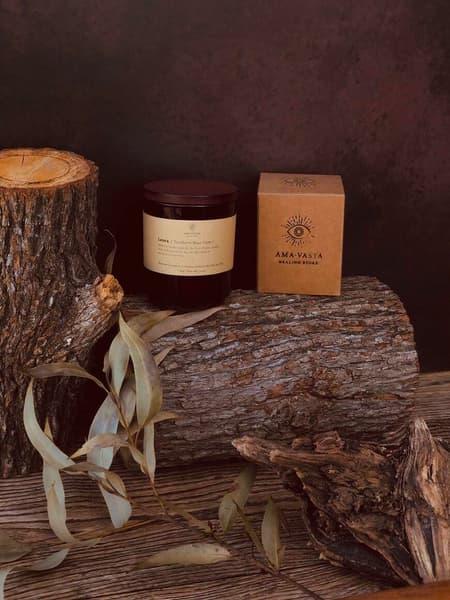 Our Leura soywax scented candle in its packaging displayed in s rustic setting