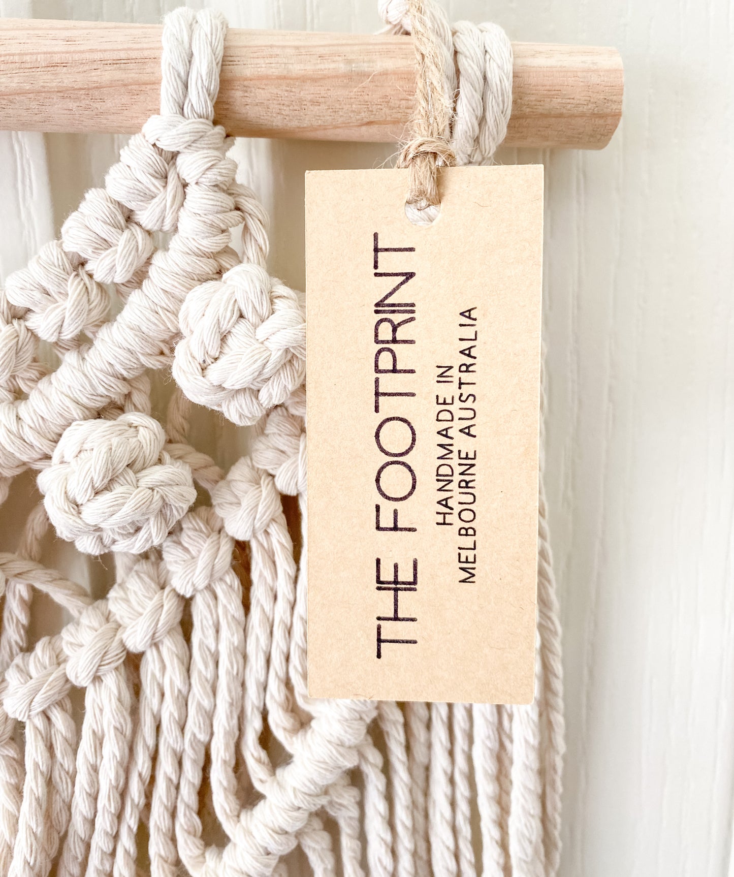 Close up image of tassels hanging witha product tag on. Product tag reads The Footprint handmade inn Melbourne, Australia