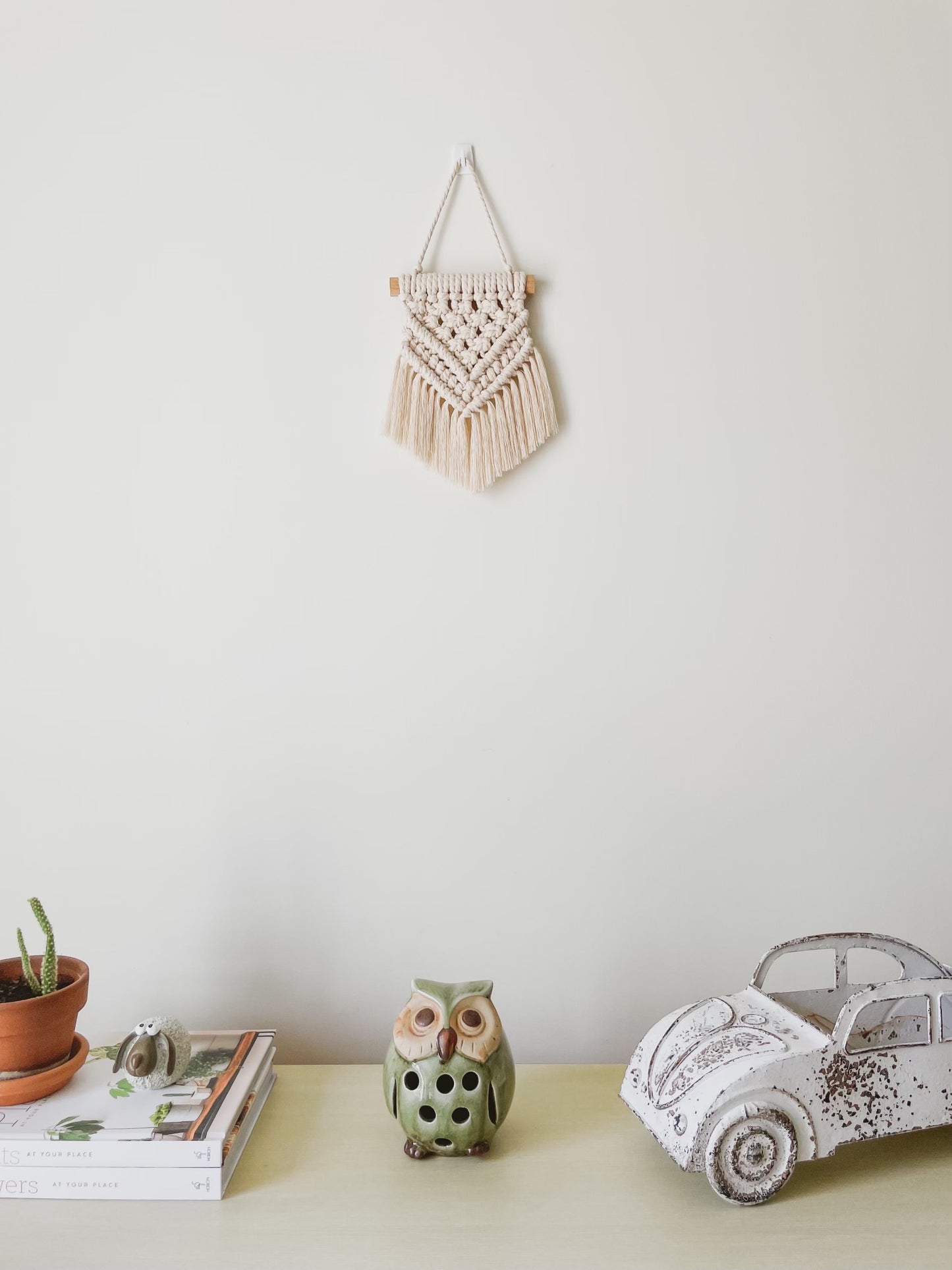 Princess mini macrame wall hanging hanged above a side board styled with rustic decor